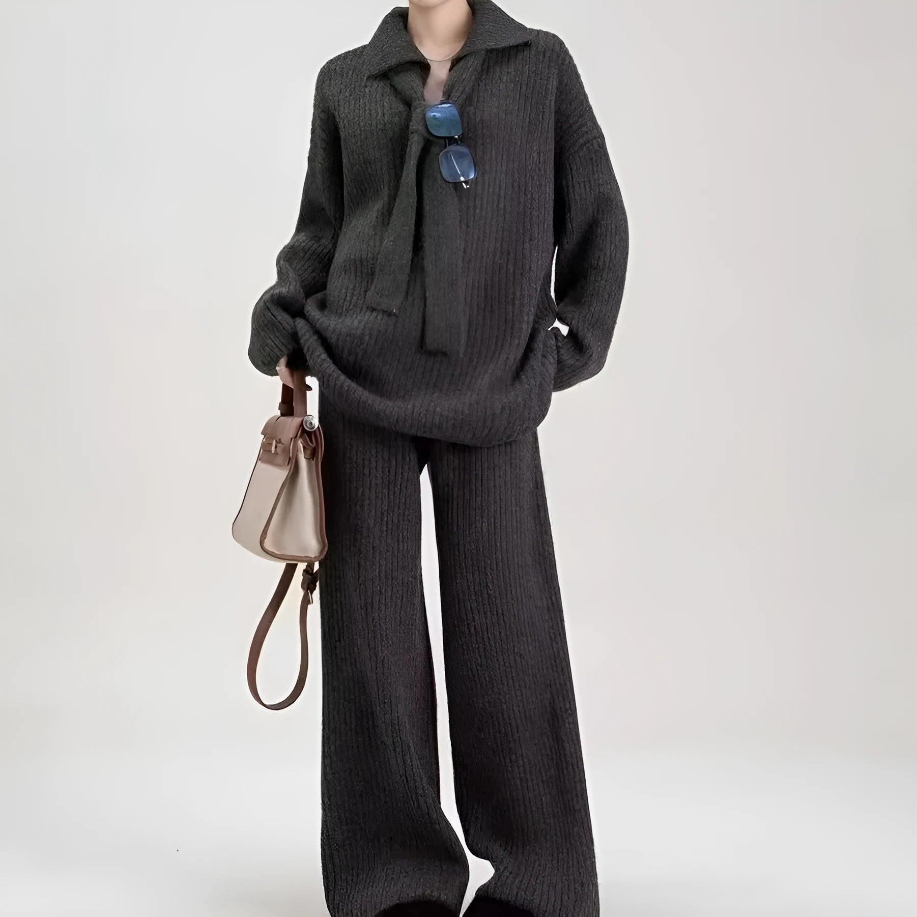 Woman wearing a beige acrylic knit sweater top and matching trousers from a casual two-piece set.