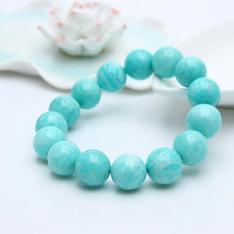 Blue-green amazonite gemstone bracelet with round beads on a black elastic cord.