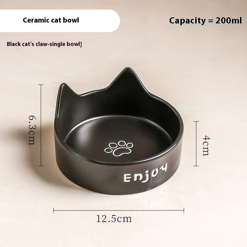 Porcelain cat bowl with cat ear handles in a wooden anti-tumble frame, showing paw print design.