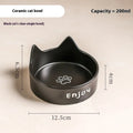 Porcelain cat bowl with cat ear handles in a wooden anti-tumble frame, showing paw print design.