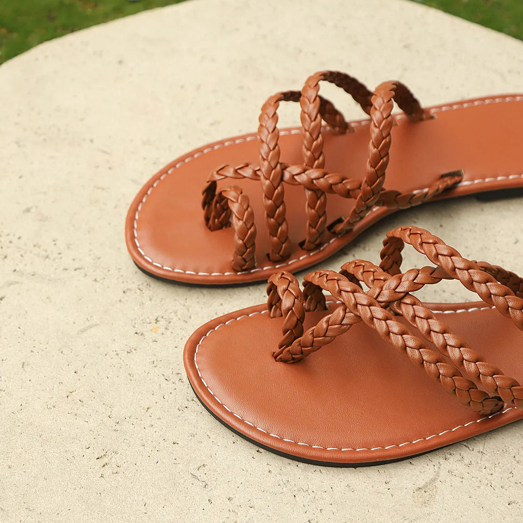 Women's woven flat sandals with a clip-toe strap in artificial PU, showing a rubber sole.