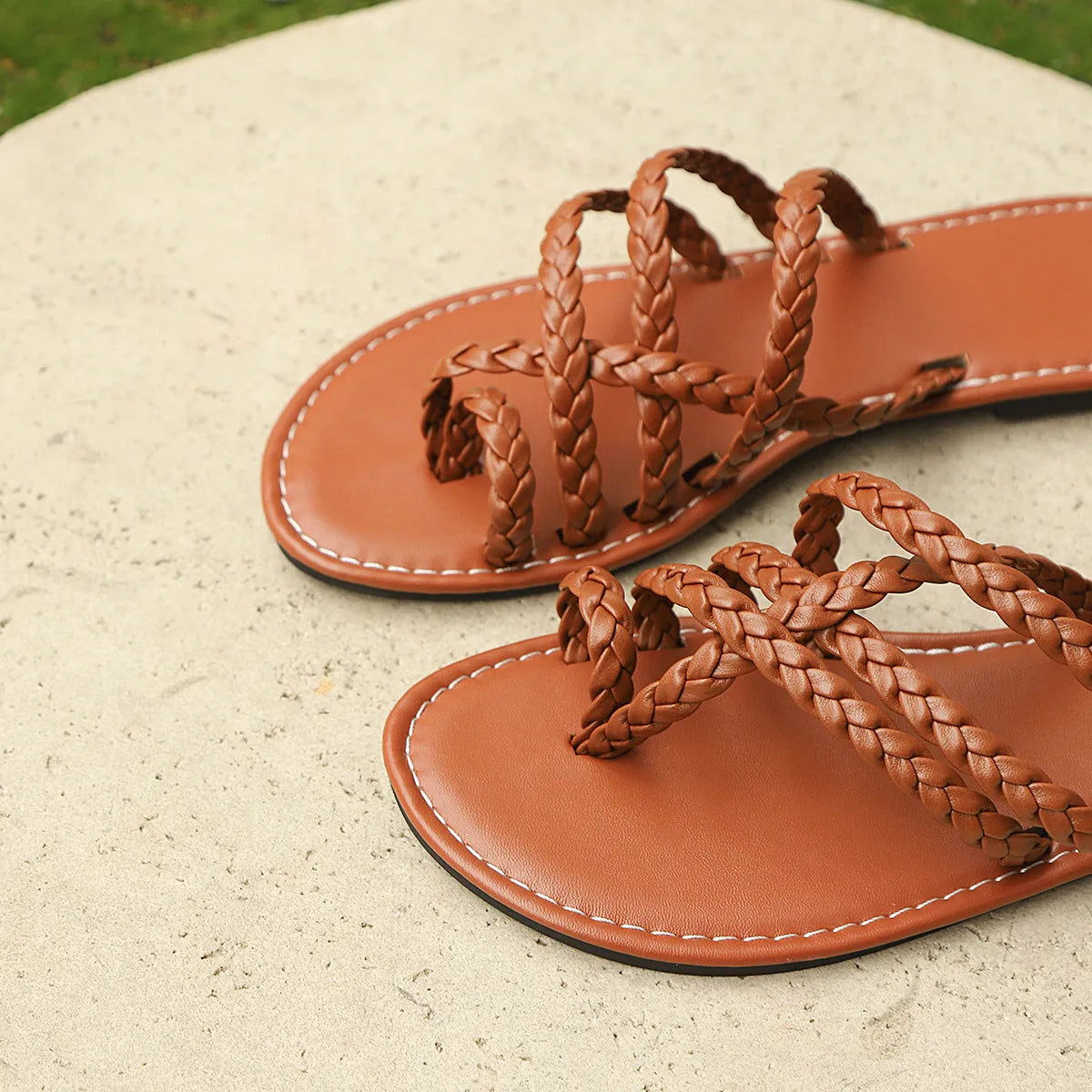 Women's woven flat sandals with a clip-toe strap in artificial PU, showing a rubber sole.