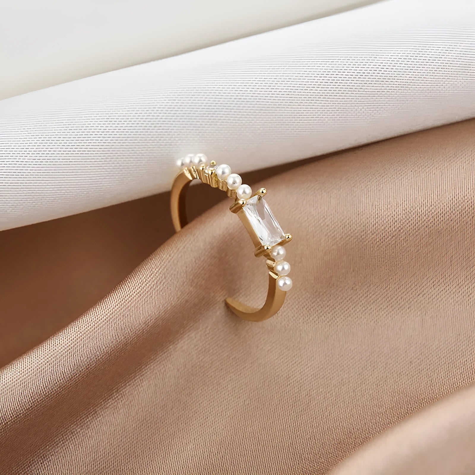 Gold alloy ring with square artificial gemstone inlay and diamond-cut surface, adjustable opening, on a white background