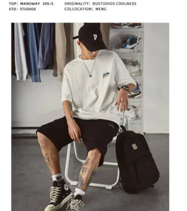 Plus size man modelling a loose fit short-sleeved t-shirt in black, dark grey, or white.