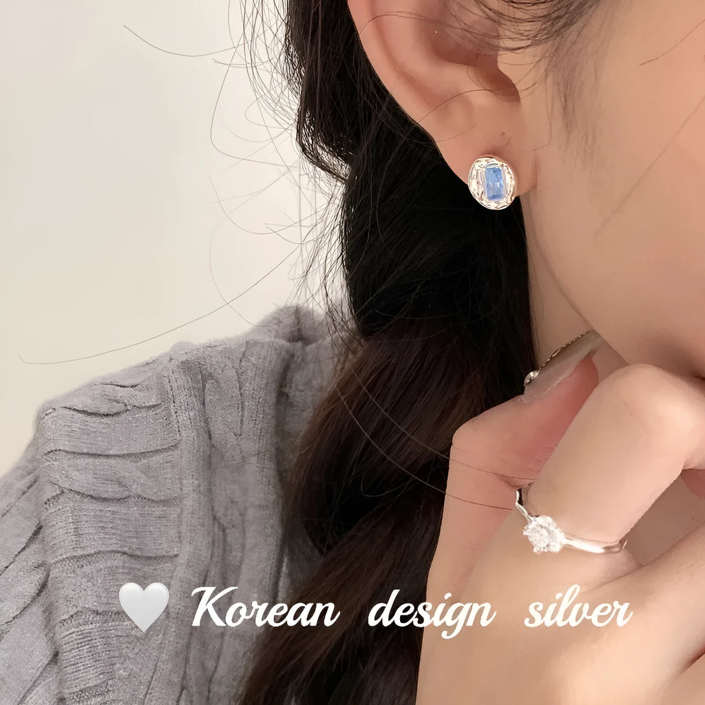 S925 sterling silver earrings with geometric heart-wrapped design and oval blue diamond elements