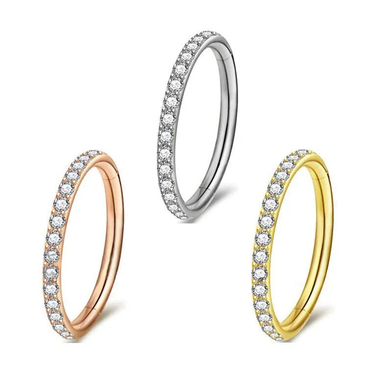A stainless steel seamless nose ring with a diamond setting, shown in gold, rose gold, black, and steel finishes.