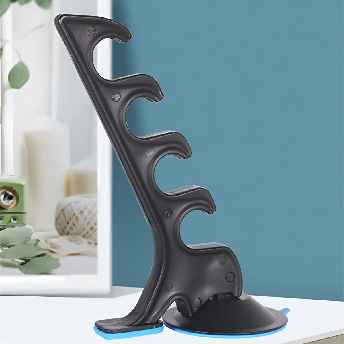 Black plastic car fishing rod bracket with suction cup mount for holding one fishing rod in a vehicle.
