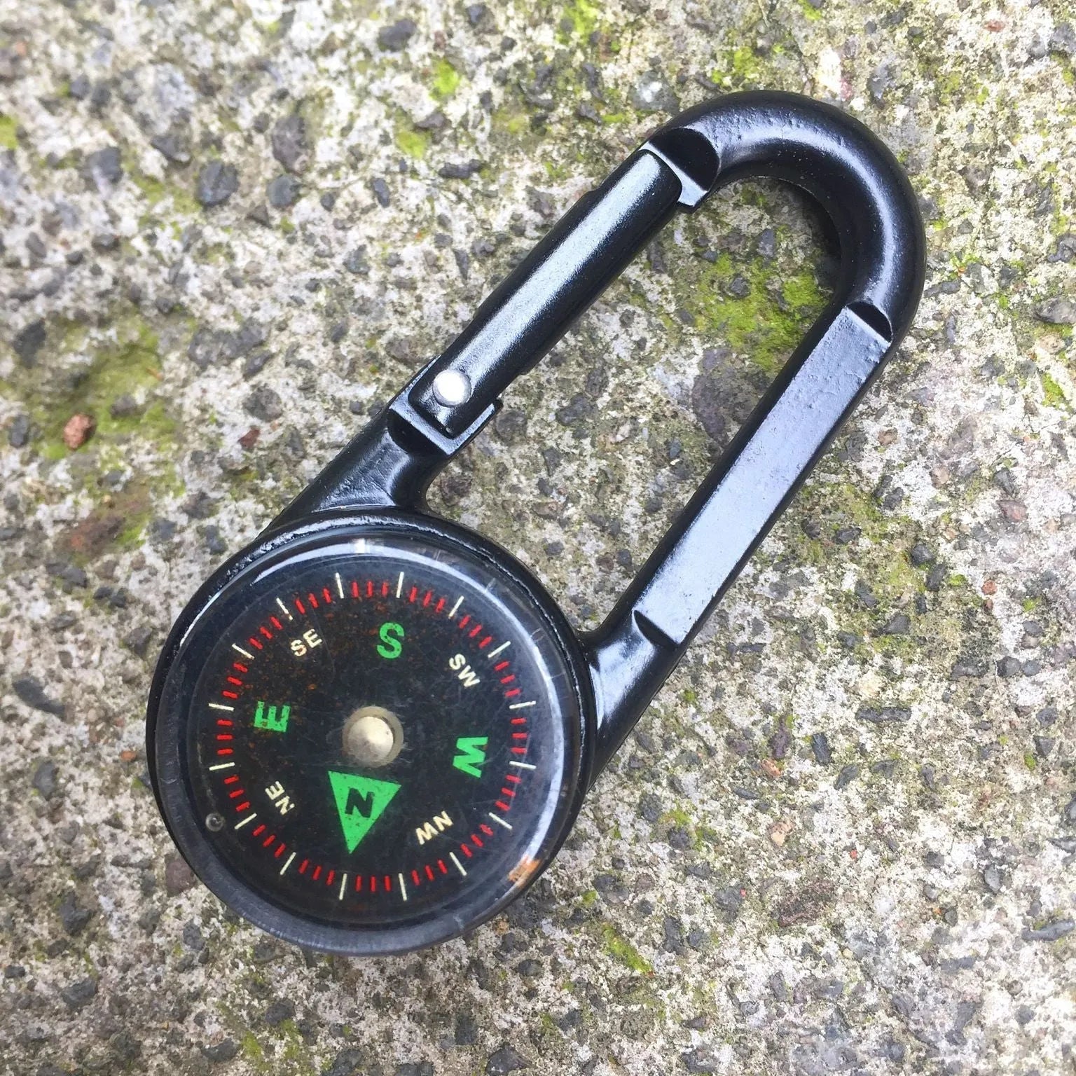 Black zinc alloy camping carabiner with built-in compass and thermometer, showing double-sided button and 65mm size.