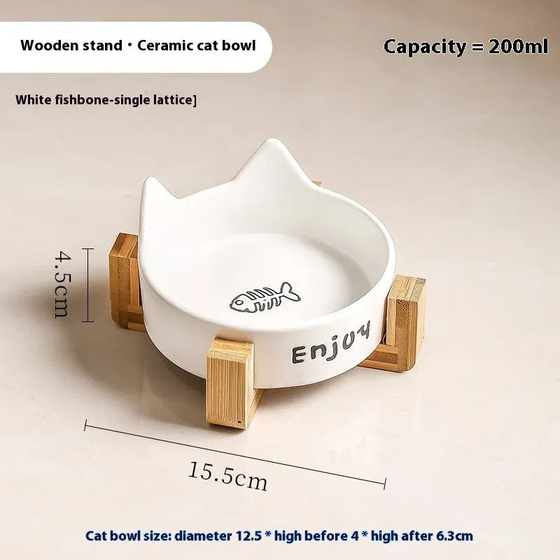 Porcelain cat bowl with cat ear handles in a wooden anti-tumble frame, showing paw print design.