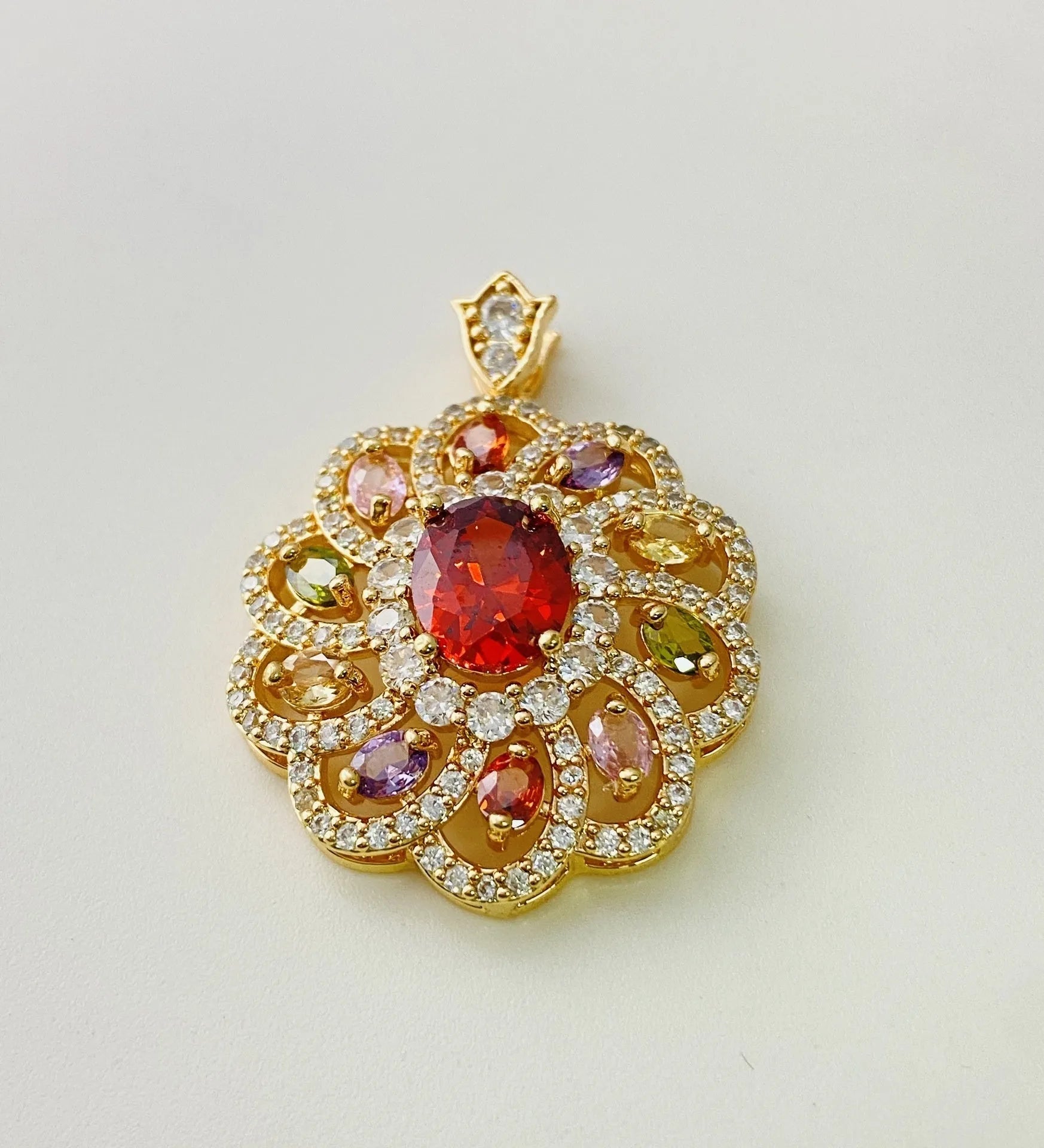 Close-up of a women's floral-shaped colourful zircon pendant necklace in a gold metal setting.
