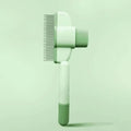 Green and yellow pet grooming brush with one-click hair removal and anti-mite cleaning bristles for dogs