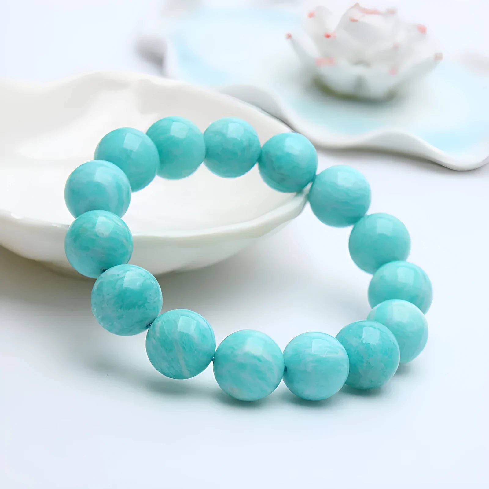Blue-green amazonite gemstone bracelet with round beads on a black elastic cord.