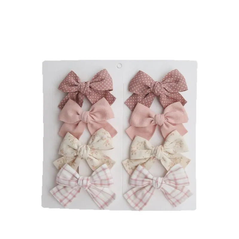 Dovetail bow hairclips for children in multiple colour patterns including beige grid dots and blue flowers