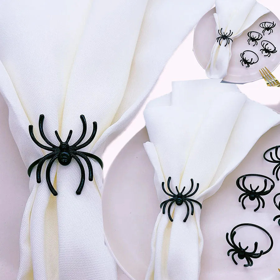 Set of six black metal spider-shaped napkin rings for Halloween table decorations.