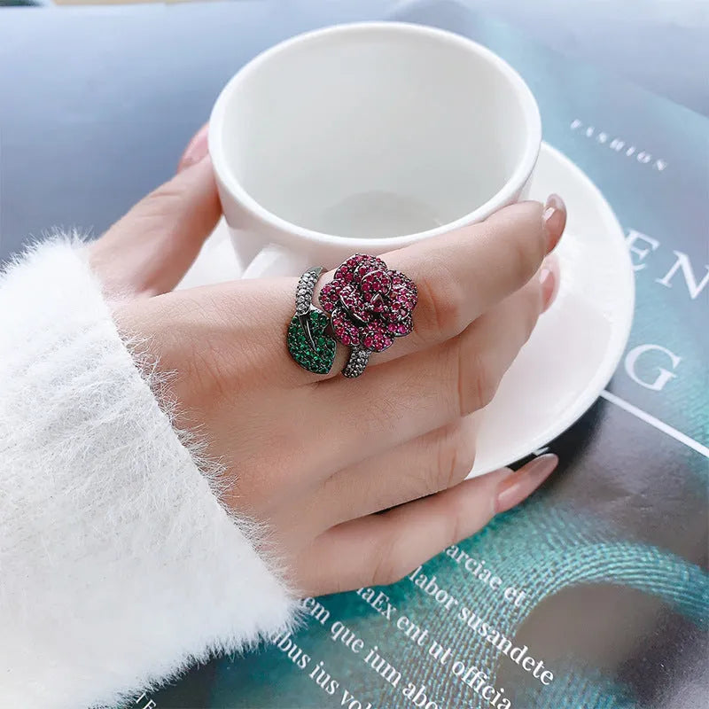 Geometric black gold ring with red simulated corundum centrepiece in flower design