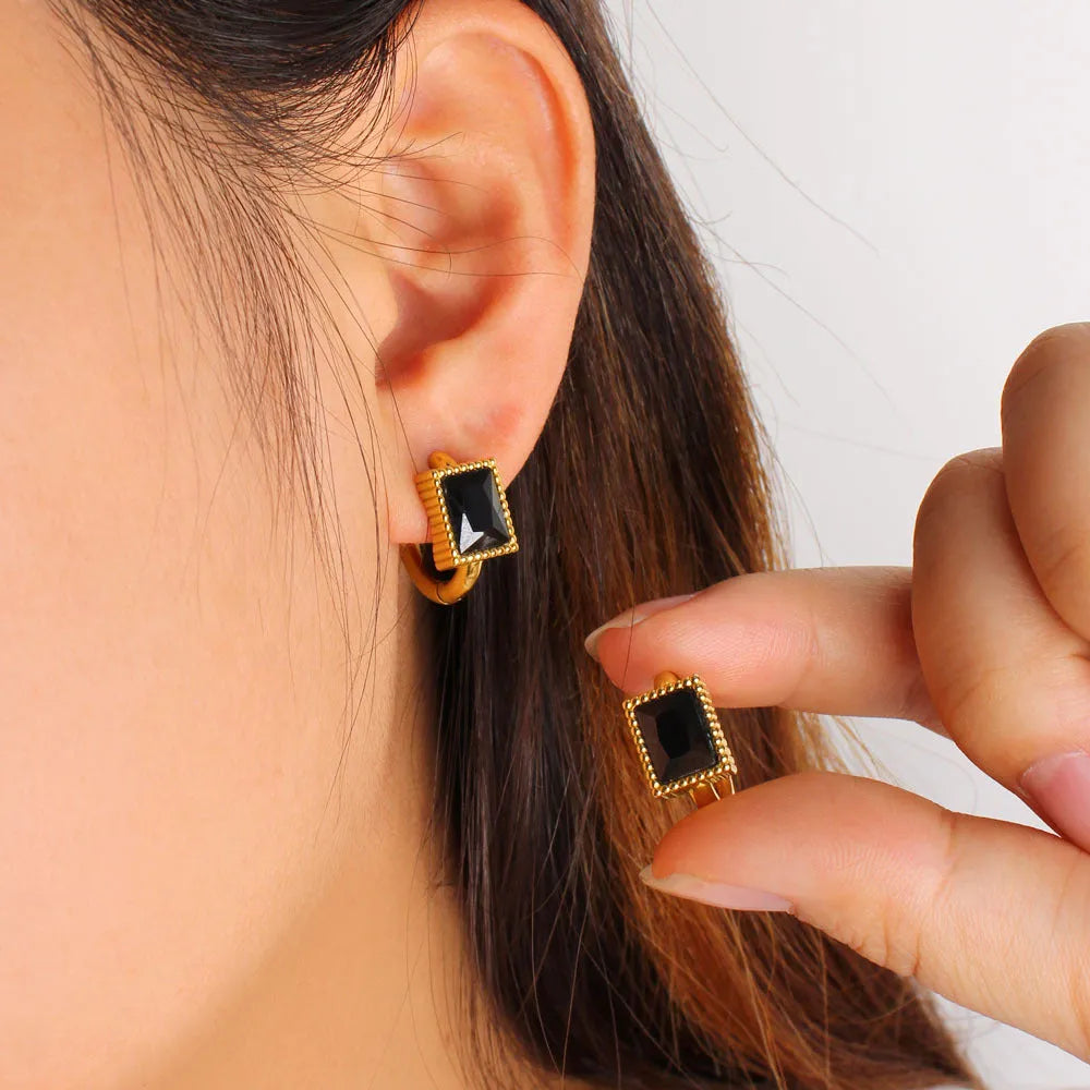 Square geometric stainless steel earrings with round ring details in white, black, or green.