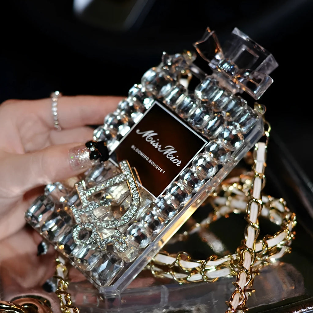 Perfume bottle bow design iPhone case with a metal chain strap in black, gold, pink, or transparent colours.