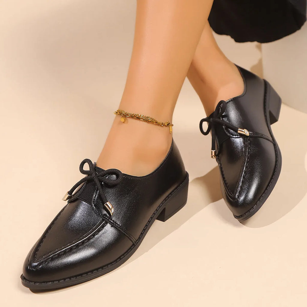 Women's beige PU leather slip-on shoes with a large bow decoration and rubber sole.
