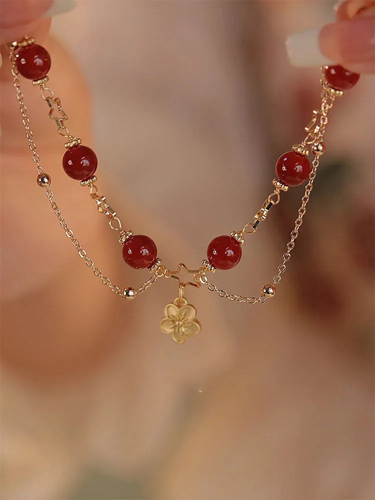 Close-up of a red agate double layer women's bracelet with floral and peach blossom motifs.