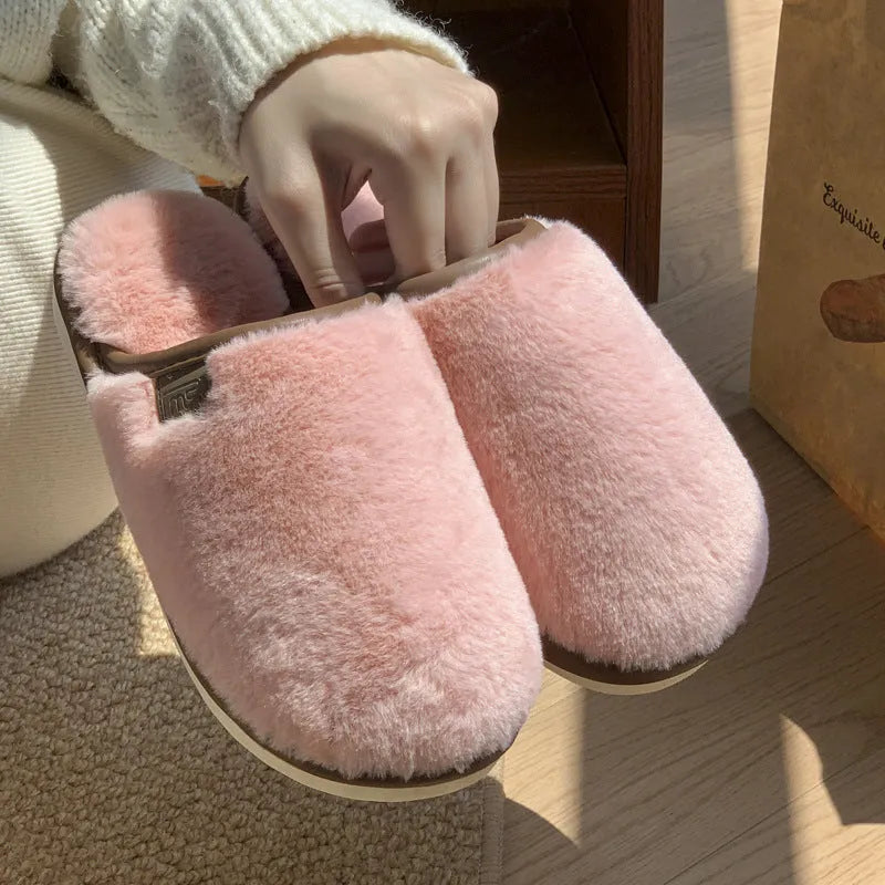 Pair of solid-colour plush winter slippers with a PVC upper and non-slip sole.