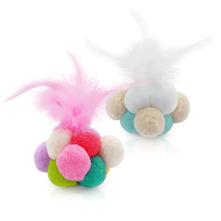 Cat toy feather bouncy ball with colourful pink feathers on a light background