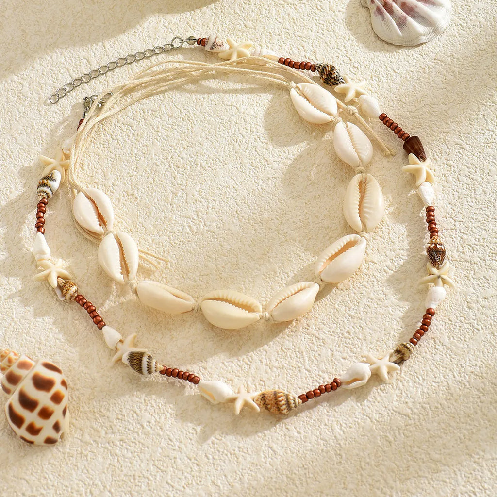 Handcrafted bohemian shell necklace with geometric pendant on a regular chain, colour X1900.
