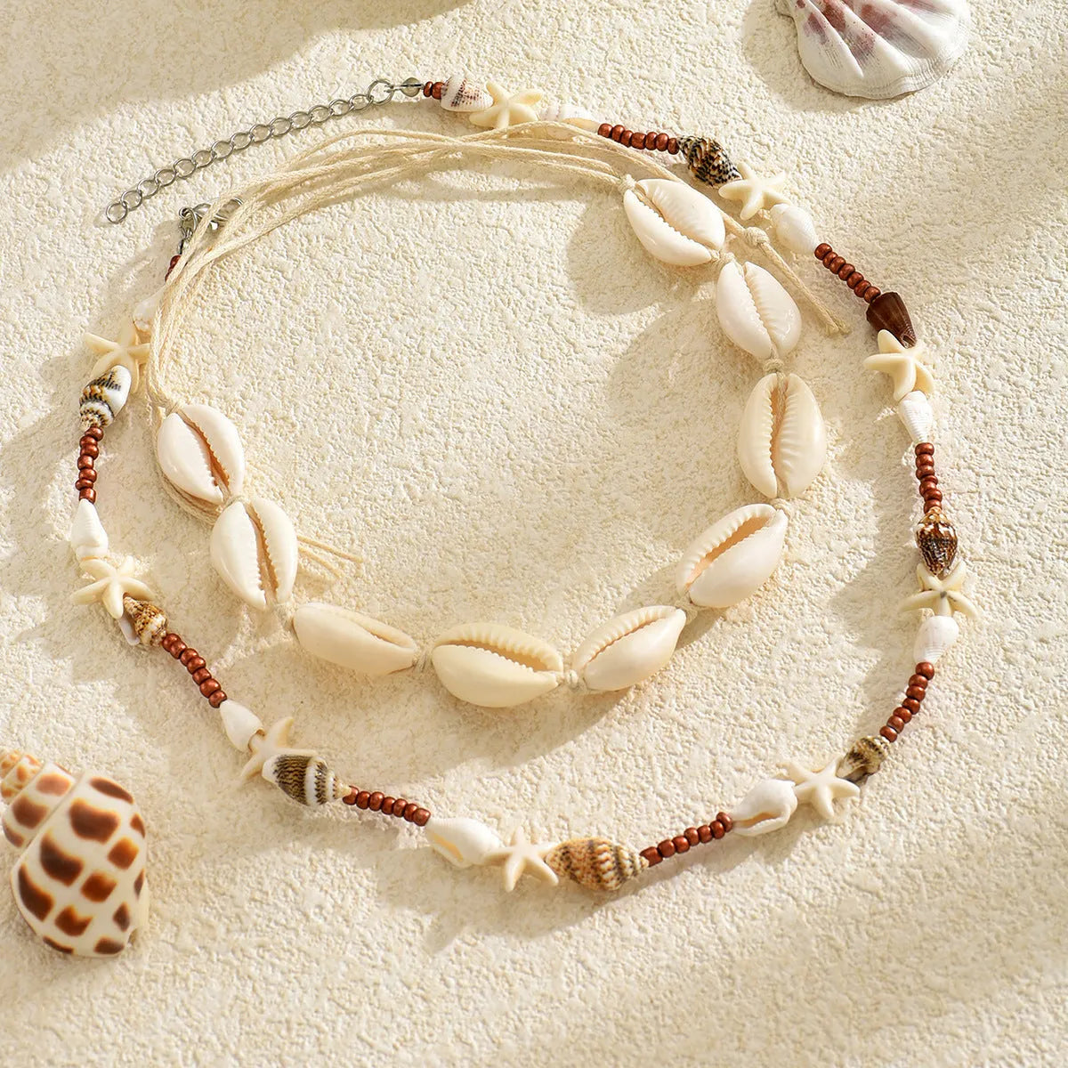 Handcrafted bohemian shell necklace with geometric pendant on a regular chain, colour X1900.