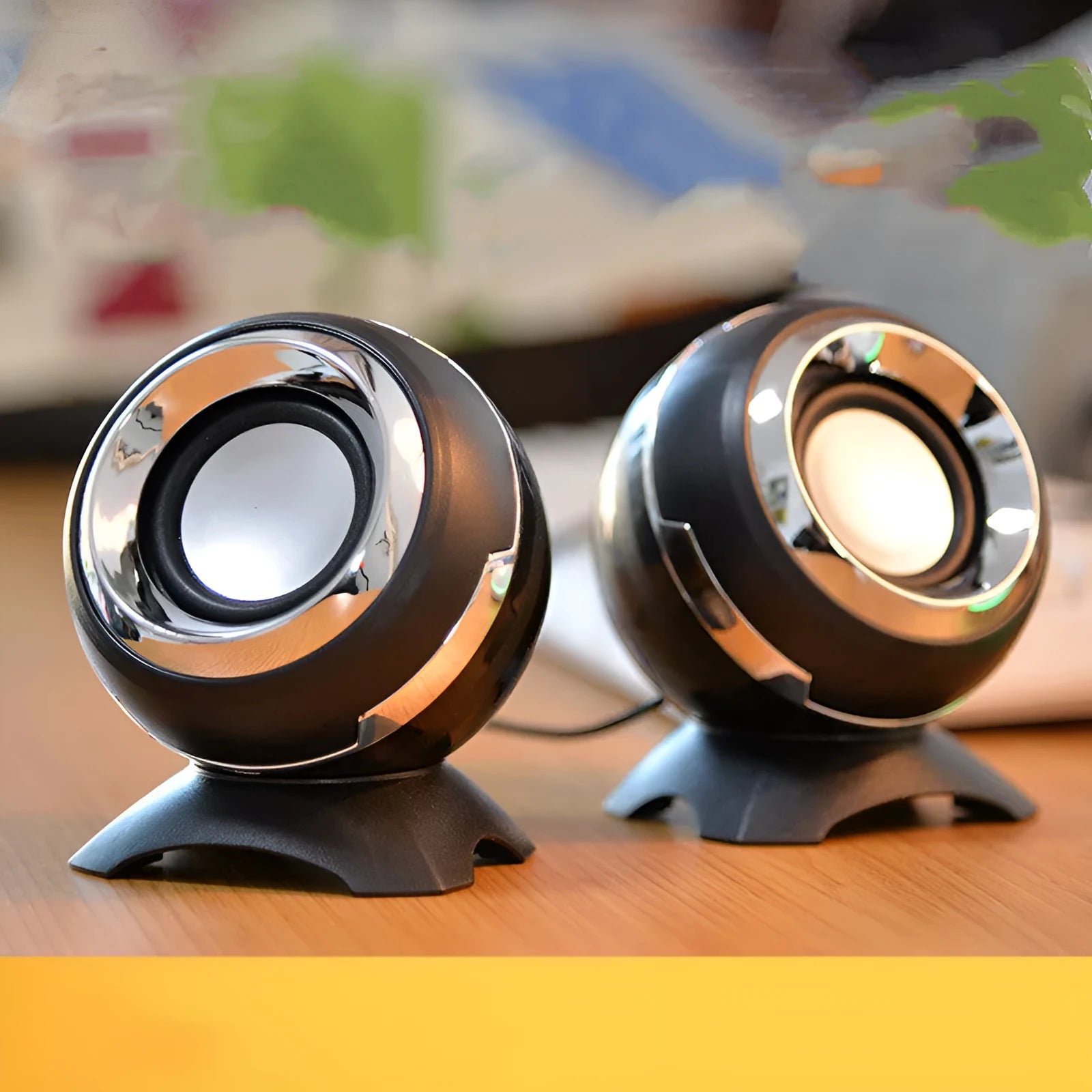 Compact black and gold USB-powered stereo computer speakers beside laptop