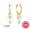 Close-up of sterling silver sunflower earrings with golden zirconia stones on a white background.