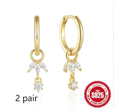Close-up of sterling silver sunflower earrings with golden zirconia stones on a white background.