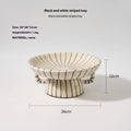 Black and white striped synthetic resin fruit plate on a table.