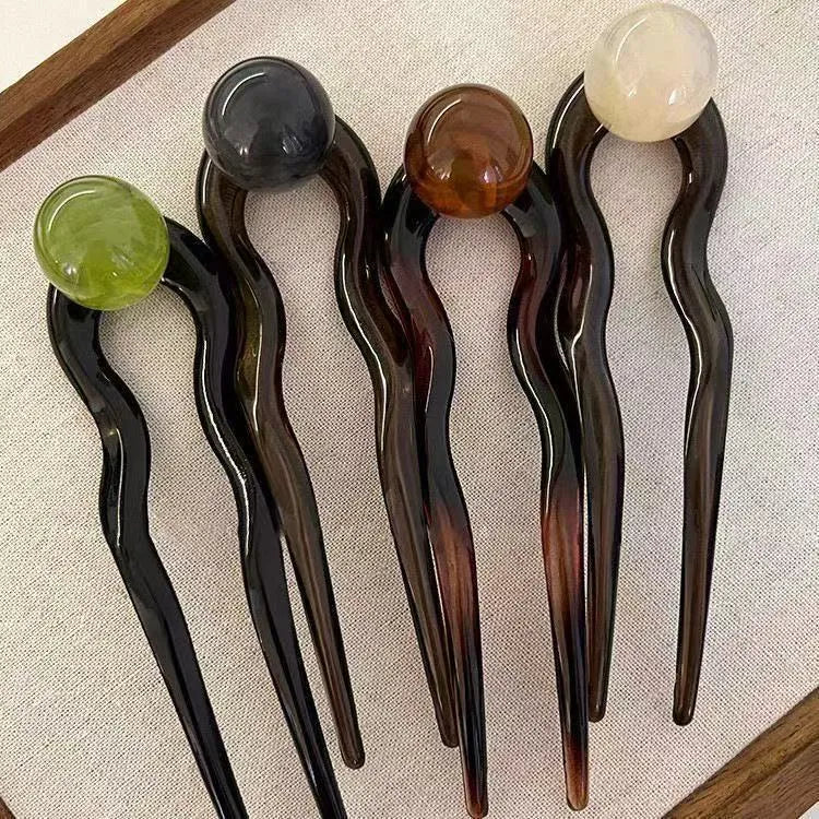 Acrylic U-shaped hair barrettes with ball decoration in beige, caramel, dark grey, and green colours