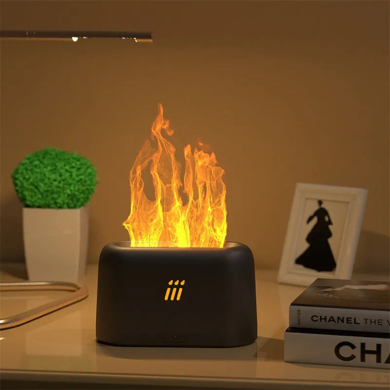 Black round ultrasonic aroma diffuser humidifier with flame effect LED lights and remote control on a table.