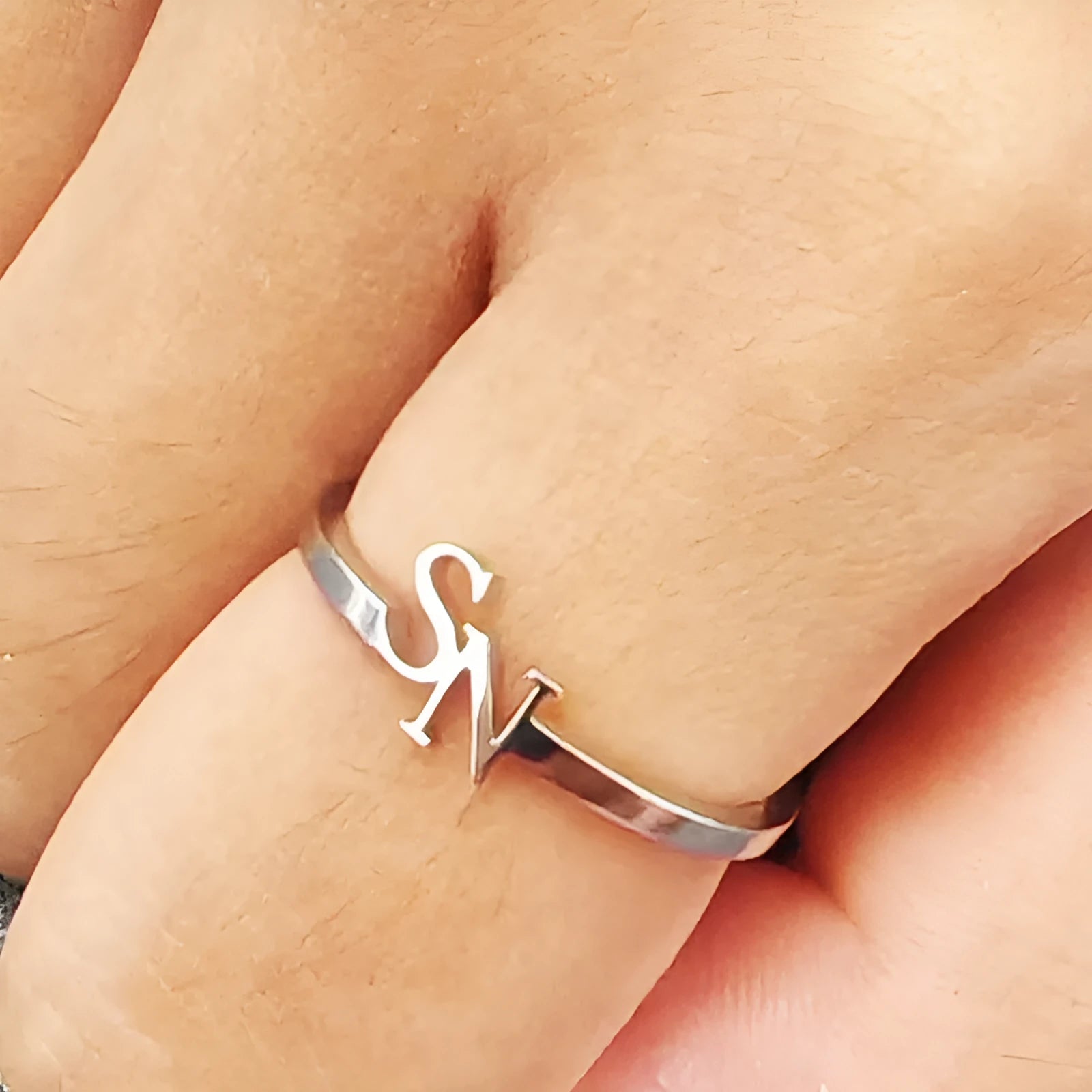 Customised 2 letters open ring in stainless steel with gold electroplated finish on a plain background