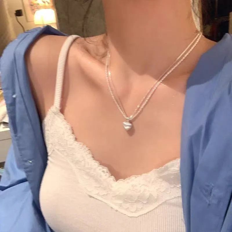 Double-layer heart pendant necklace in brushed silver finish with adjustable chain