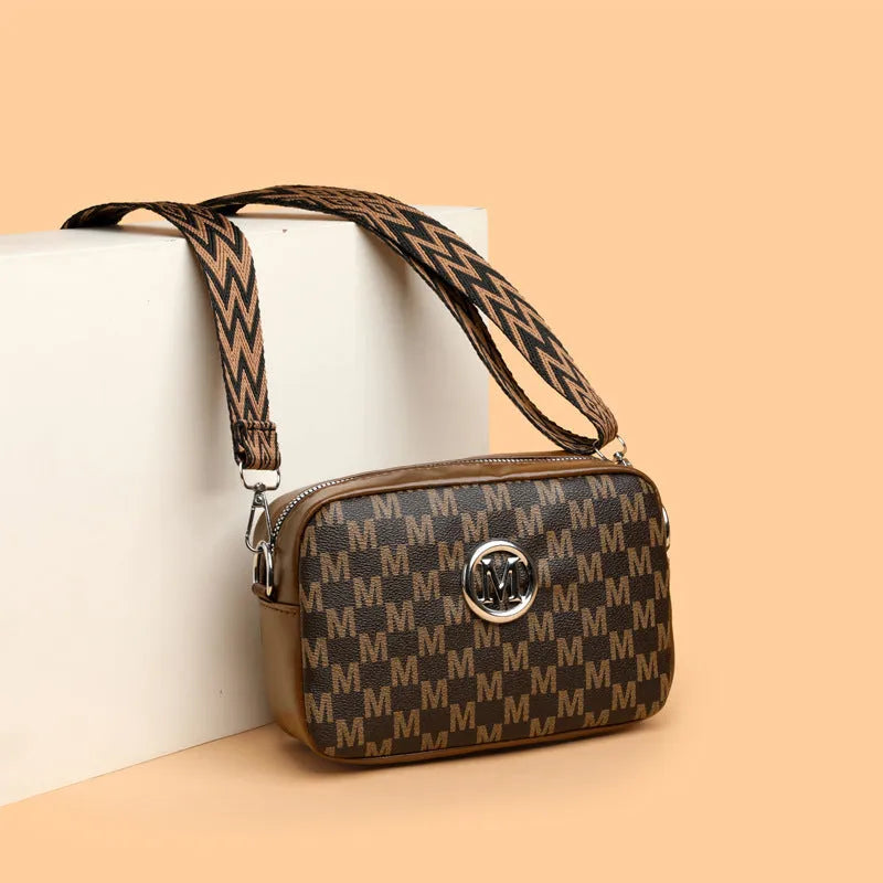 Crossbody bag with wide shoulder strap in black colour showing three-dimensional pocket construction
