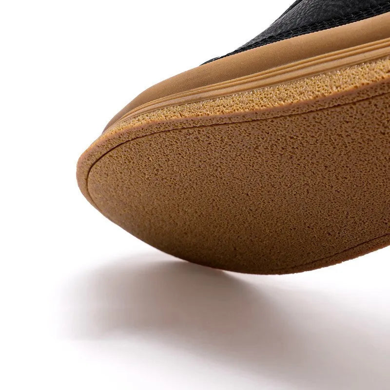 Men's black leather casual shoes with round toe and white flat rubber sole on a plain background