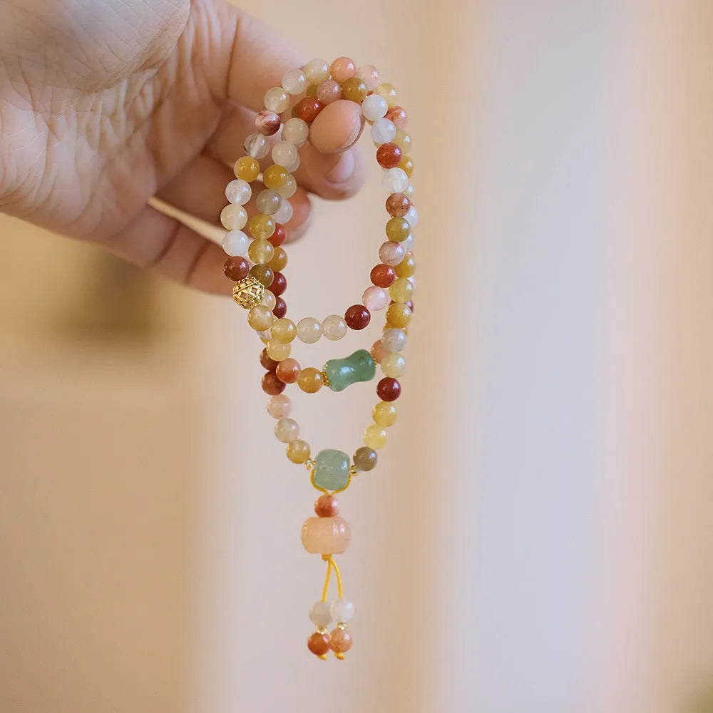 Women's Jinsi Jade bracelet with three-circle pumpkin design and tassels on a wrist
