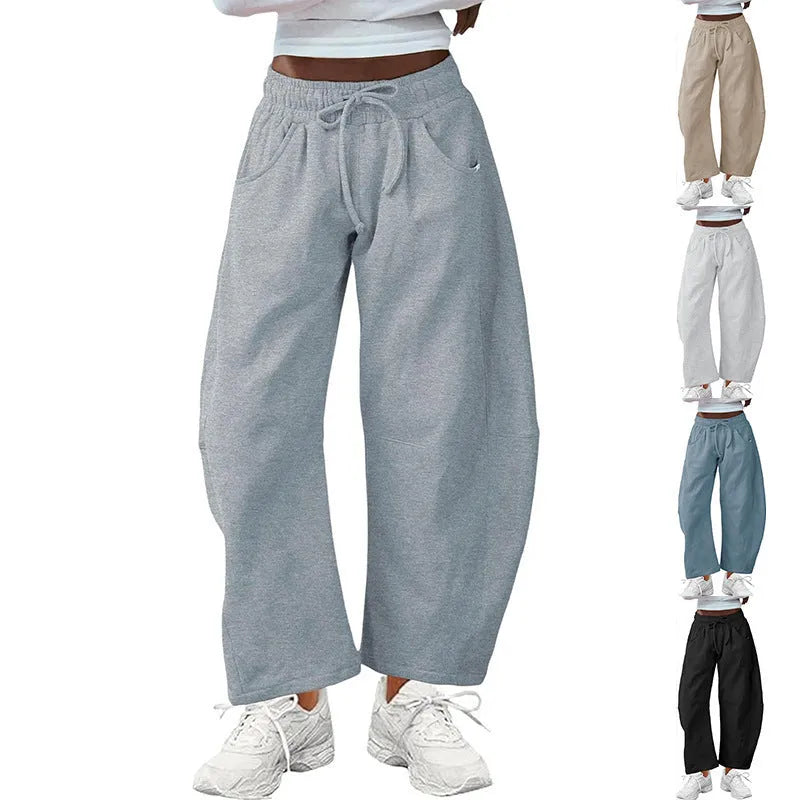 Women's loose cropped sweatpants in apricot colour with drawstring waist and side pockets on a neutral background.