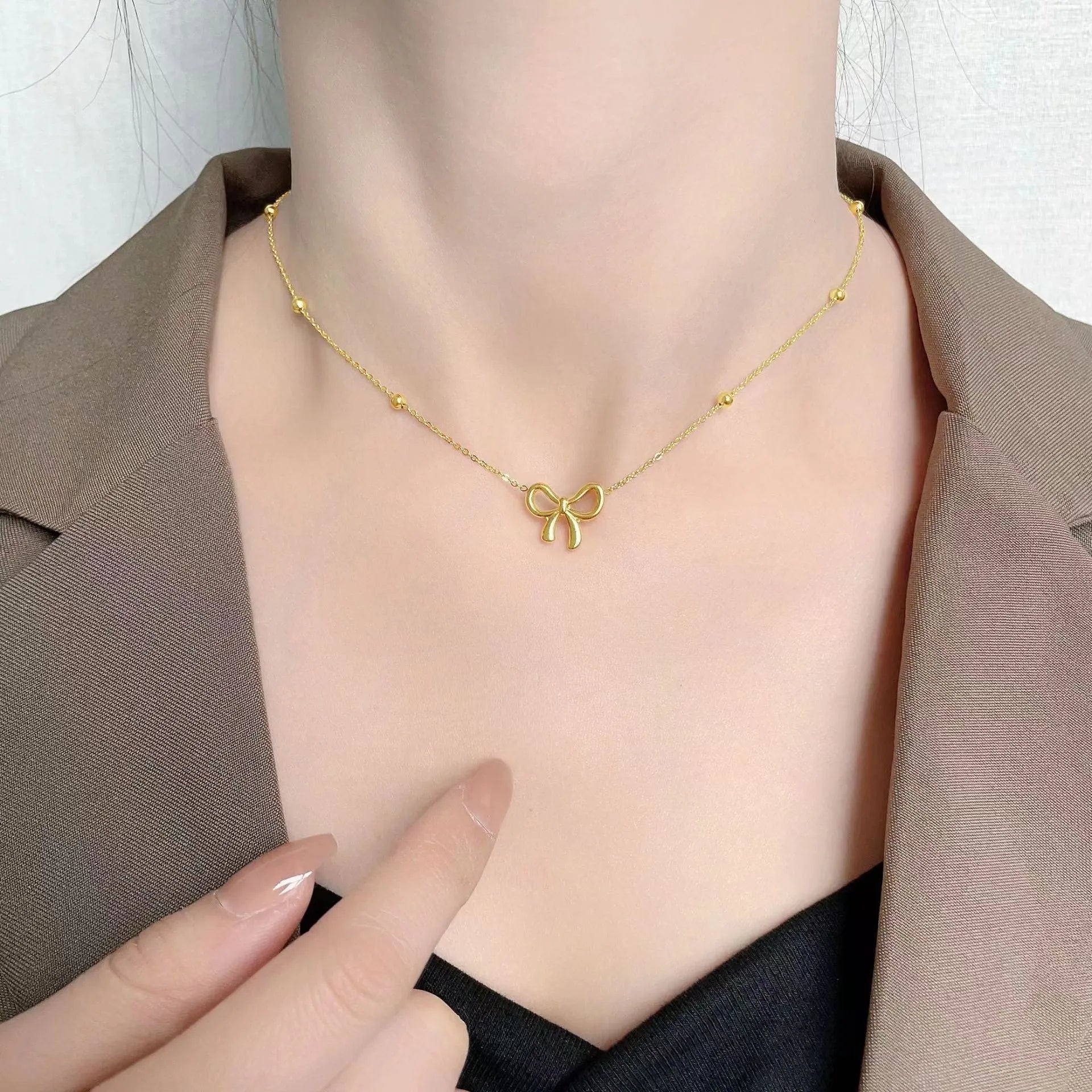 Gold titanium steel bow necklace for women with adjustable length and cross chain design