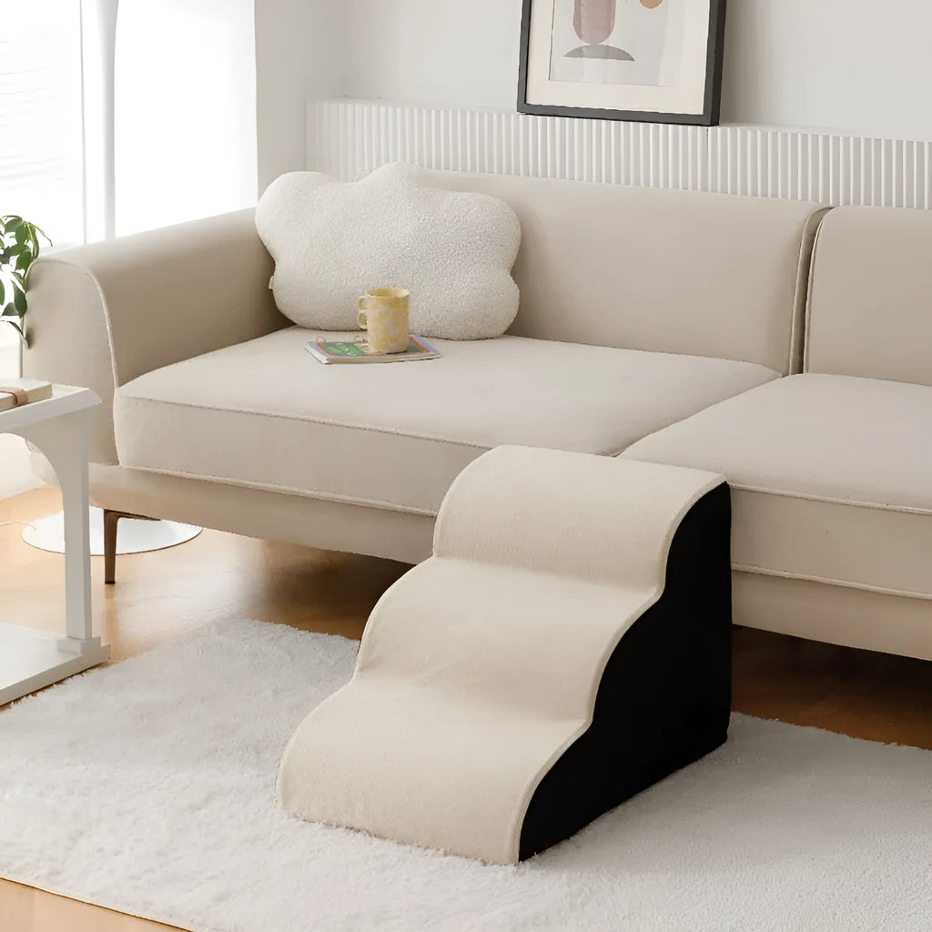 Brown wooden pet stairs with removable fabric steps helping a small dog reach a sofa