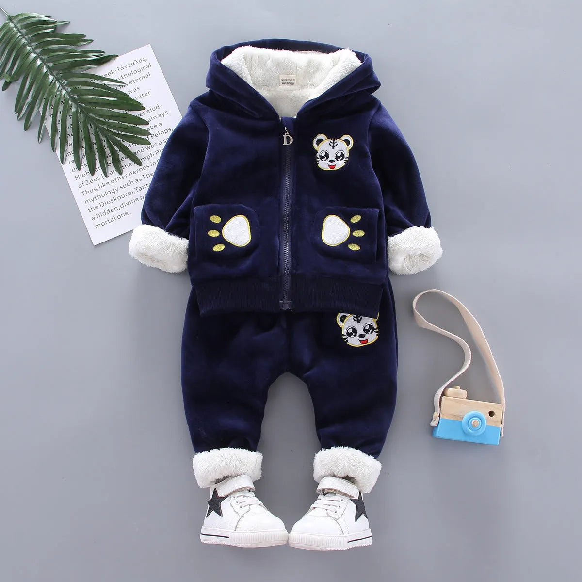 Child wearing a long sleeve golden mink fleece pyjama set with cartoon animal pattern in navy blue for winter