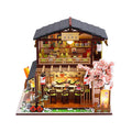 Assembled wooden Japanese sushi restaurant model with flash function, 21 by 32 by 5.5 centimetres, on a white background.