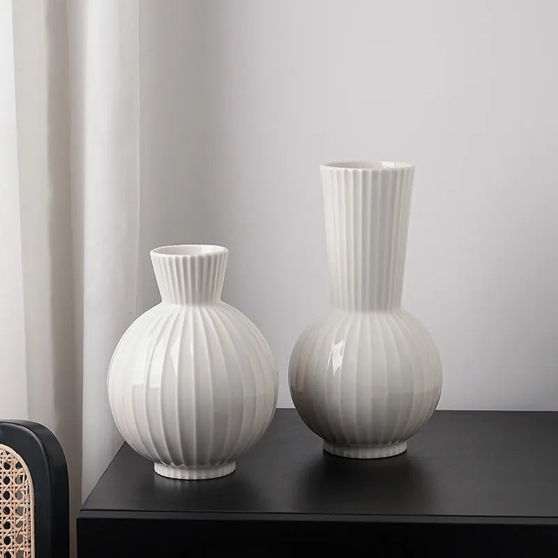 White ceramic vase with blue stripes in ball shape on wooden table