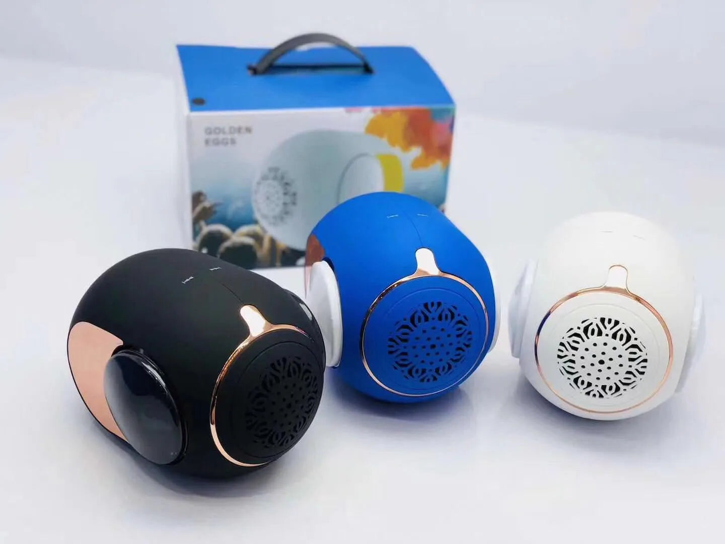 Small golden egg-shaped wireless Bluetooth speaker in black, white, or blue colour with charging cable.