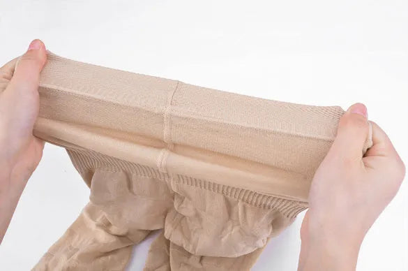 Black seamless high-waist shapewear shorts laid flat, showing the tummy control panel and leg openings.
