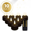 Set of four black flameless LED tealight candles on a surface.