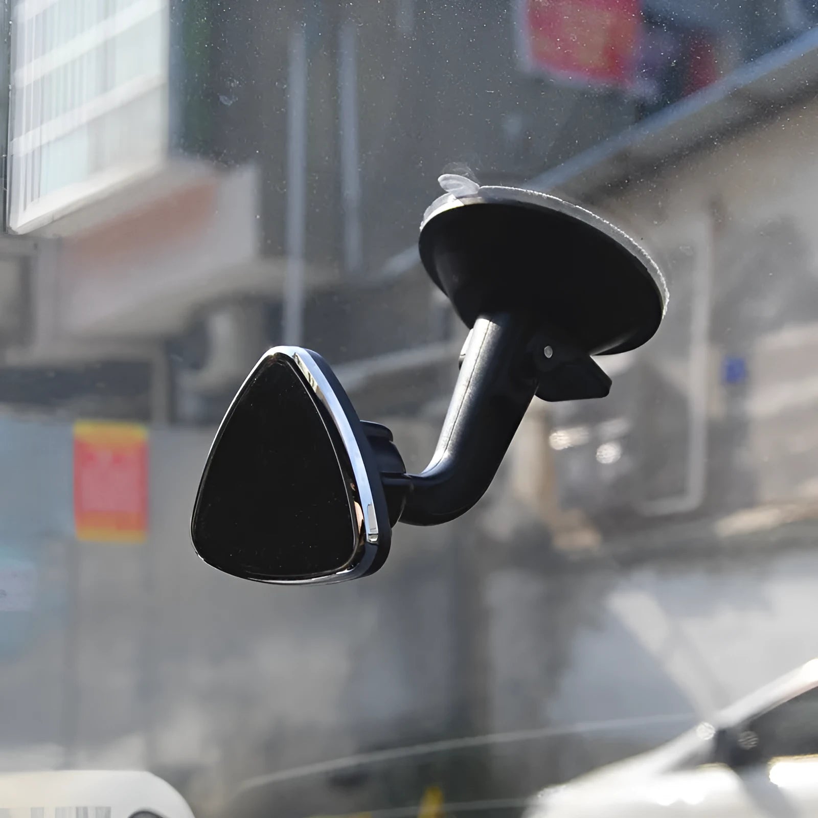Black magnetic car phone holder with 360-degree rotating bracket mounted on a car dashboard.