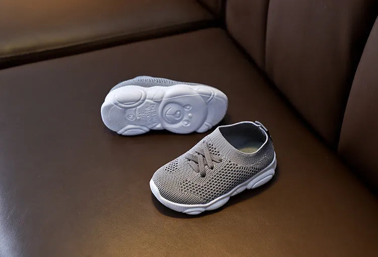 Children's lazy slip-on shoes in white, black, pink, or grey with fabric upper and rubber sole.