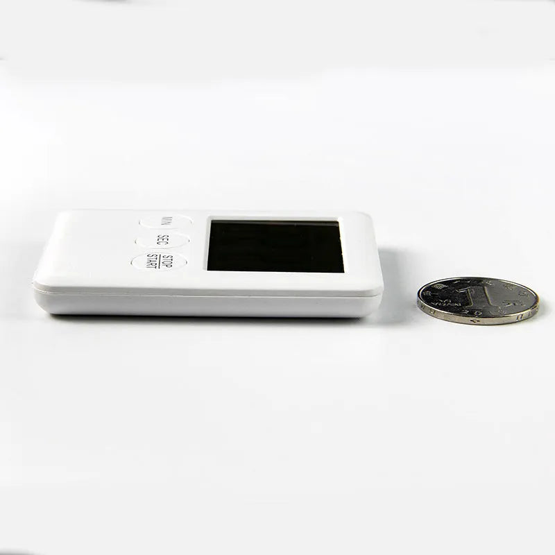 Black and white digital kitchen timer with LED display shown on a magnetic refrigerator door.
